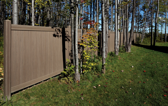 Weathered Blend Bufftech Vinyl Fence Installed Near a Tree Line